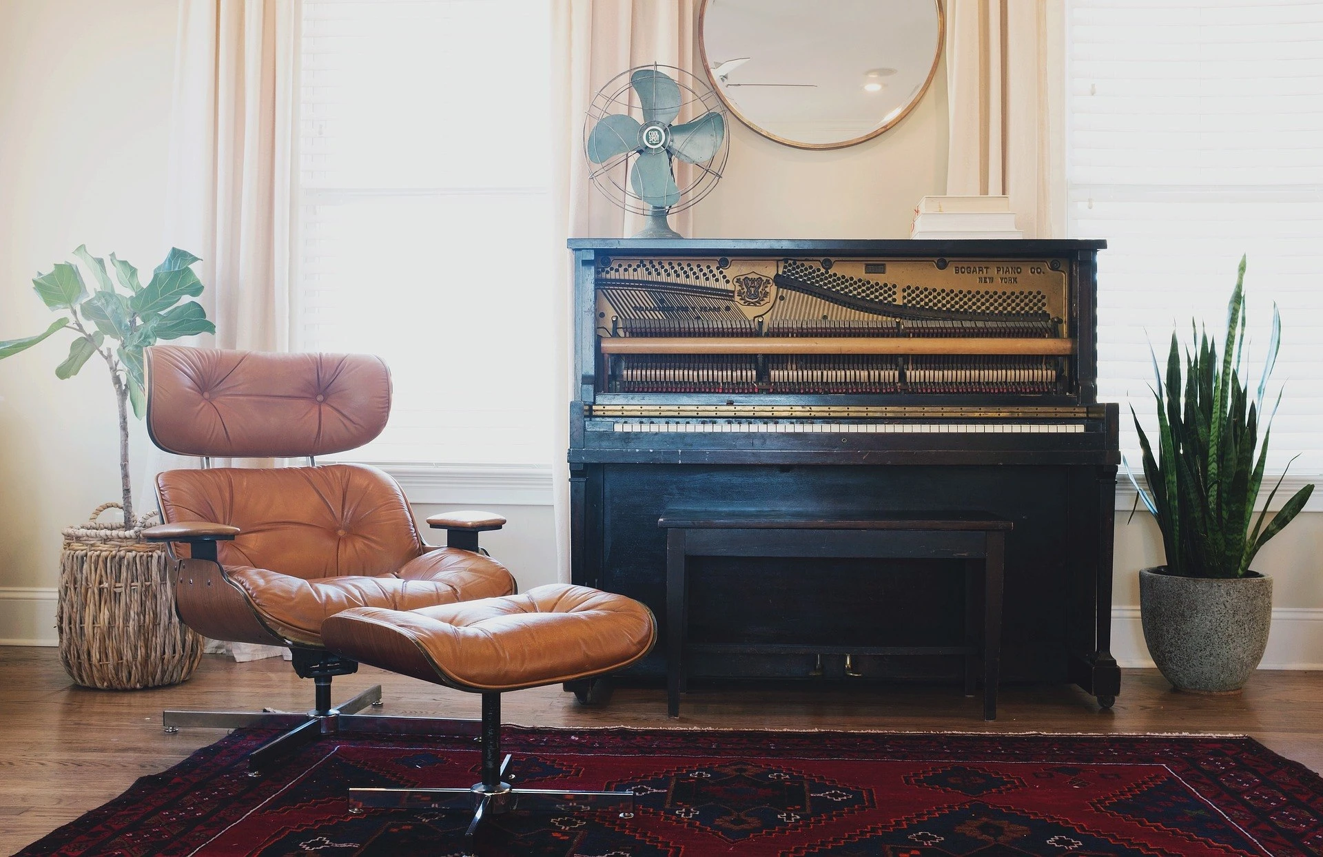 Depiction of a black piano next to a leather recliner chain in a cozy apartment