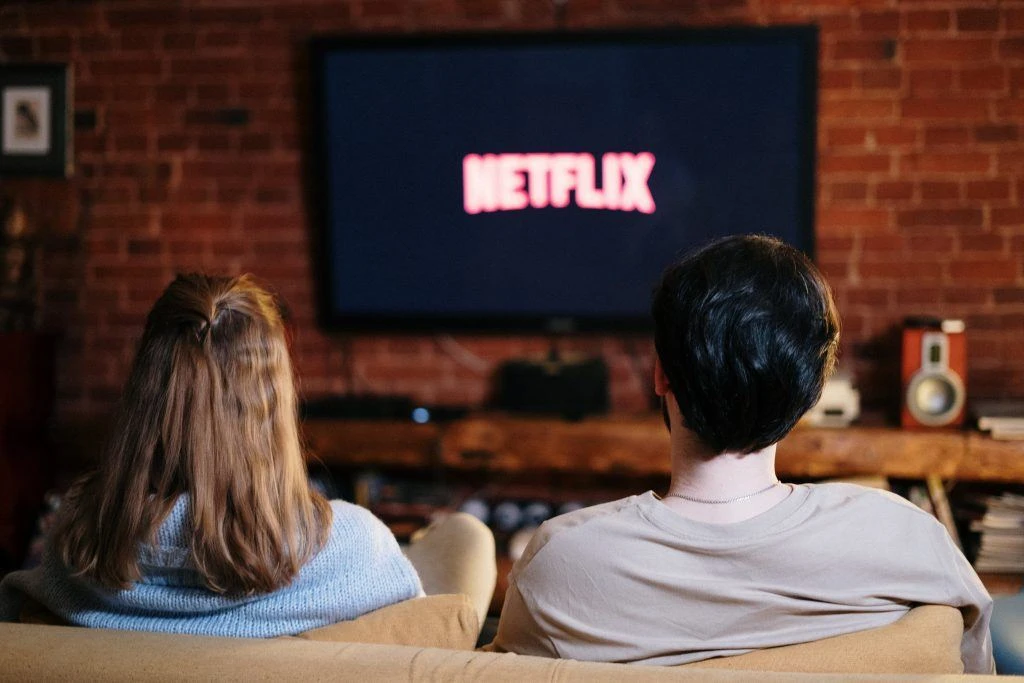 Couple taking a break from downsizing when moving by watching Netflix 